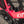 Close-up of a bright pink bicycle frame with visible SRAM and KINESIS branding, showing part of the crankset and seat-tube against an outdoor pavement background.