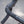 Close-up of a bicycle drop handlebar wrapped in black textured tape with small white dots, set against a blurred gray pavement background.