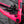 Close-up of a bright pink bicycle frame with a black SRAM brake mech attached near the rear wheel.