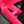 Close-up of a bright neon pink bicycle frame with glossy finish, showing structural tubing and a black cable running through the frame.