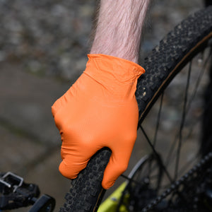 Black Mamba Orange nitrile Snakeskin Workshop gloves fitting a tyre