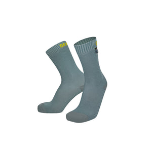 A pair of Dexshell Ultra Thin waterproof socks in a mist peak blue colour, featuring a small yellow logo on the cuff and a black brand tag on the side.