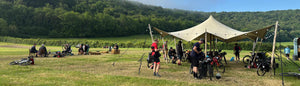 Group of people with camping gear in a field with a tent and vehicles at the 2026 Dorset Gravel Dash