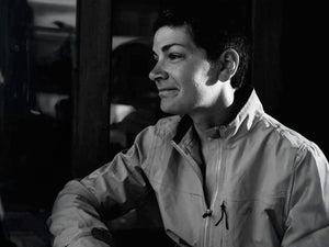 Fran Scott wearing a light-colored jacket in a dimly lit setting