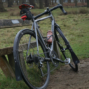 A bike with Fend Off mudguards leaning on a bench.