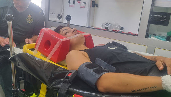 Fran lying on a stretcher with medical equipment in an ambulance.