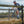 Cyclist riding a bicycle on a gravel path with a fence in the foreground