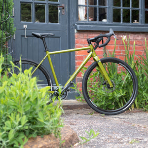 The Kinesis GX Race bike in green photographed outside the workshop.