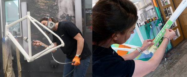 A split-screen photo showing Bex from Fat Creations in a workshop or studio. On the left, the person is wearing a white protective suit and holding a spray gun near a white frame and adjusting the downtube decals.