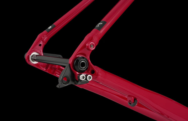 Red bicycle frame with black components on a black background