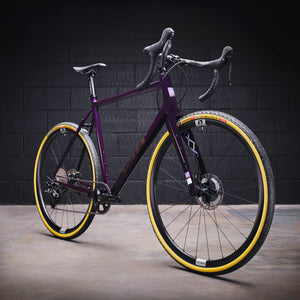 Kinesis GX Frameset in purple taken in a warehouse, three quarter view.
