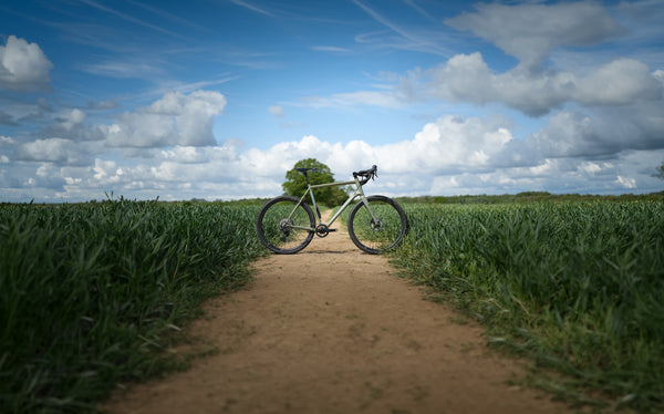 Kinesis Gravel Bicycle on a dirt path with greenery in the background, Kinesis Tripster Aluminium all terrain bike