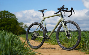 Kinesis Gravel Bicycle on a dirt path with greenery in the background, Kinesis Tripster Aluminium all terrain bike