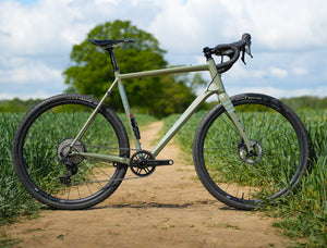 Kinesis Gravel Bicycle on a dirt path with greenery in the background, Kinesis Tripster Aluminium all terrain bike