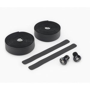 Black Kinesis 4 Seasons Grip bicycle handlebar tape set with two rolled sections of textured grip tape, two straight adhesive strips, and two black hardware knobs on a clean white background.