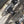 Close-up of a bicycle rear wheel showing a black Reynolds hub, silver cassette, disc brake, and part of the frame with a blurred outdoor background.