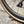 Close-up of a black bicycle wheel with a tan sidewall and embossed REYNOLDS lettering, photographed outdoors on gravel.