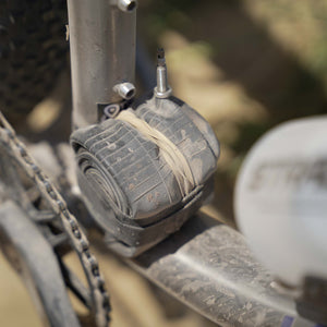 Close up of a Kinesis Fernweh MTB frame with a spare tube secured to the frame covered in dust