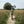 A Kinesis Fernweh MTB bicycle parked on a dirt path in a field of tall grass, with trees and a pale sky in the background.