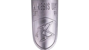 A silver aluminium head badge with the Kinesis UK logo for bicycles