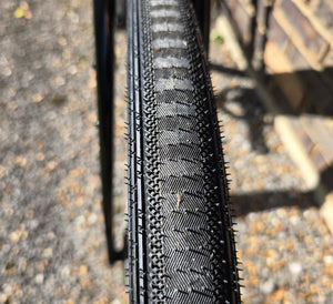 Close-up of a bicycle tyre tread pattern on a road surface