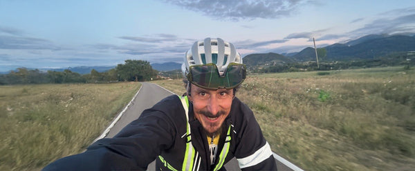 Rupert cycling on a road with mountains in the background during the VIA Race