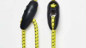 Wholegrain Cycles bungees in Bright yellow with black dotted pattern and black plastic toggle hardware, shown on a clean white background.