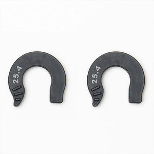 Two black horseshoe-shaped plastic spacers with the number 25.4 printed in white on the left side, shown on a plain white background.