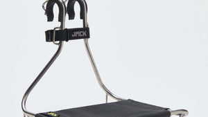 A Wholegrain Cycles Jack Classic bicycle rack with a black fabric platform and silver metal frame, featuring two black U-shaped handles on top with a black strap labeled 'JACK'.