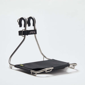 A Wholegrain Cycles Jack Classic bicycle rack with a black fabric platform and silver metal frame, featuring two black U-shaped handles on top with a black strap labeled 'JACK'.