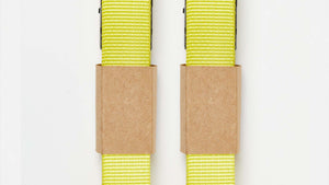 Two bright yellow Wholegrain Cycles Stiff Straps with brown kraft paper bands, shown vertically on a plain white background.